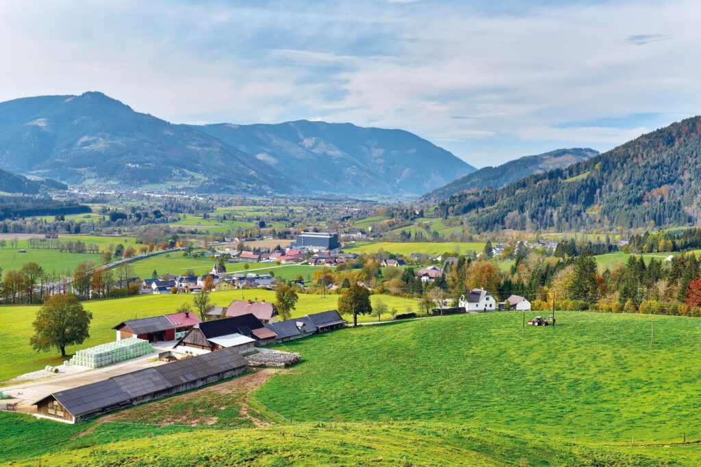 Blick auf ein steirisches Dorf inmitten einer Berglandschaft